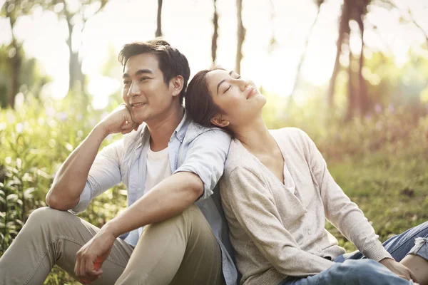 Joven asiático pareja relajante en parque — Foto de Stock