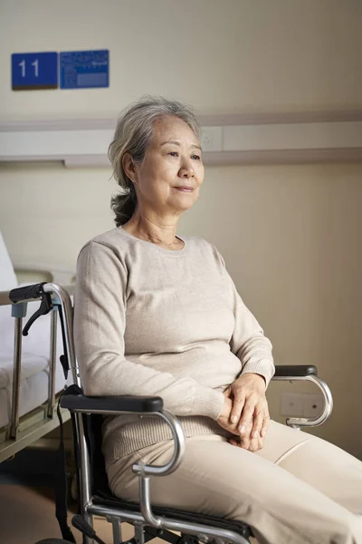 Idős ázsiai nő ül kerekesszékben az idősek otthonában — Stock Fotó