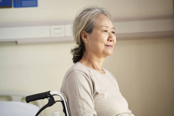 Senior asian woman sitting in wheel chair in nursing home — Stock Photo, Image