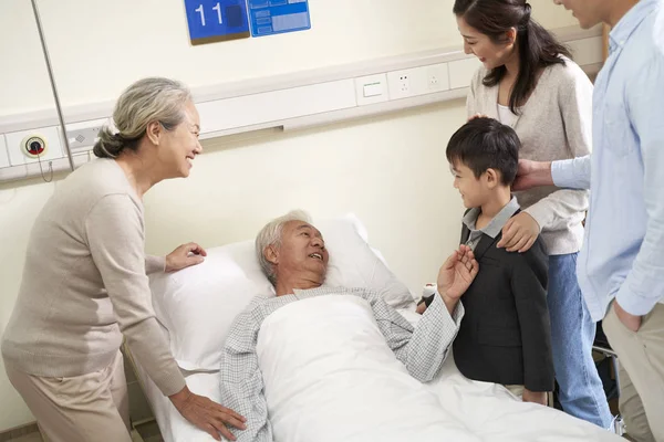Asian family visiting grandpa in hospital — Stock Photo, Image