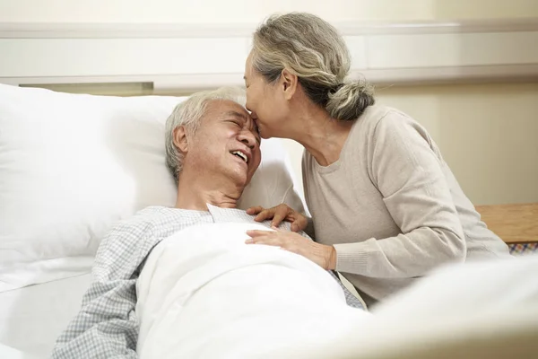 Азіатська старша жінка відвідує чоловіка в лікарні — стокове фото