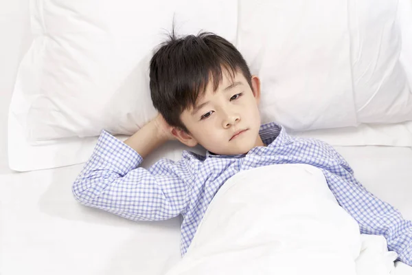 Niño de cinco años acostado en la cama en el hospital — Foto de Stock