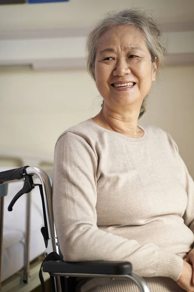 Щаслива стара жінка сидить у інвалідному кріслі в будинку престарілих — стокове фото
