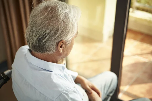 Magányos ázsiai idős férfi ül tolószékben az idősek otthonában — Stock Fotó