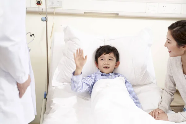 Cinco año viejo asiático niño saludando adiós a doctor — Foto de Stock