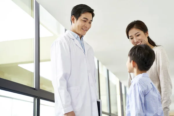 Joven asiático médico hablando a madre e hijo en hospital — Foto de Stock