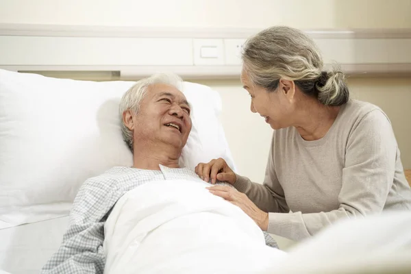 Loving Caring Senior Asian Woman Visiting Talking Hospitalized Husband Bedside — 스톡 사진