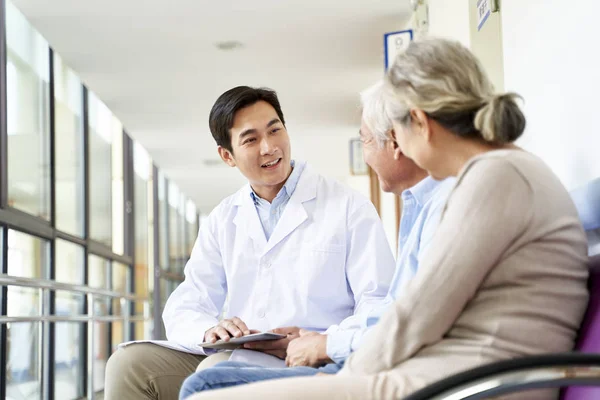 Amichevole Giovane Asiatico Medico Parlando Vecchio Coppia Ospedale Corridoio — Foto Stock