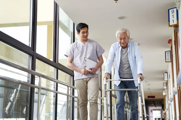 Joven Asiático Fisioterapeuta Trabajando Con Senior Hombre Caminar Usando Walker —  Fotos de Stock