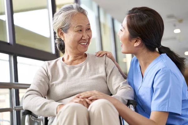 Friendly Caregiver Nursing Home Talking Asian Senior Woman Hallway — ストック写真