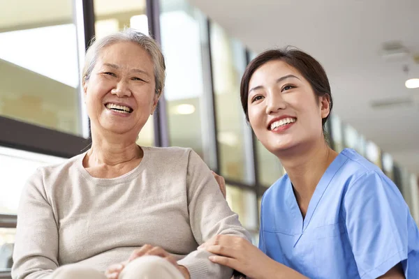 Aziatische Senior Vrouw Haar Verzorger Kijken Naar Camera Glimlachen — Stockfoto