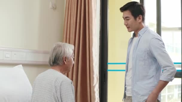 Young Adult Asian Son Talking Consoling Senior Father Hospital Nursing — Stock Video