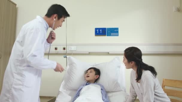 Asiatischer Kinderarzt Untersucht Patientin Und Spricht Mit Mutter Auf Krankenhausstation — Stockvideo