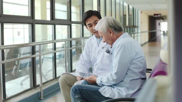 Genç Asyalı Doktor Yaşlı Çifte Hastane Koridorlarında Test Sonuçlarını Söylüyor — Stok video