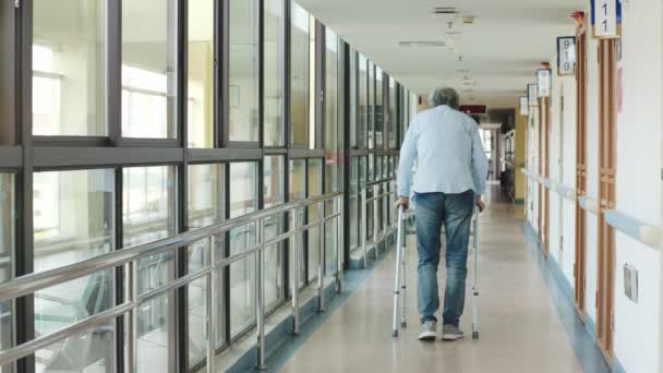 在养老院走廊里的一位步行者的帮助下 亚洲老年人缓缓行走的后视镜 — 图库视频影像