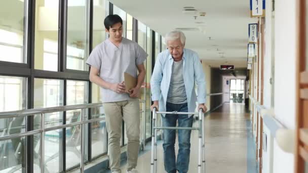 Young Asian Physical Therapist Working Senior Man Walking Using Walker — Stock Video