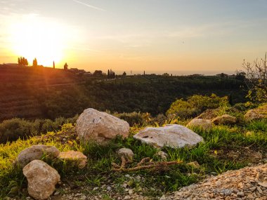 Günbatımı manzarasının arka planında bir taş