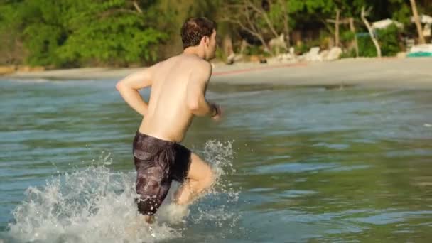 Uomo Che Corre Fuori Dall Oceano Alla Spiaggia Mentre Schizza — Video Stock