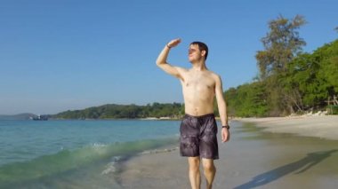 Çıplak ayaklı sırt çantası gezgini Tayland 'daki güzel tropik plajda yürüyor.