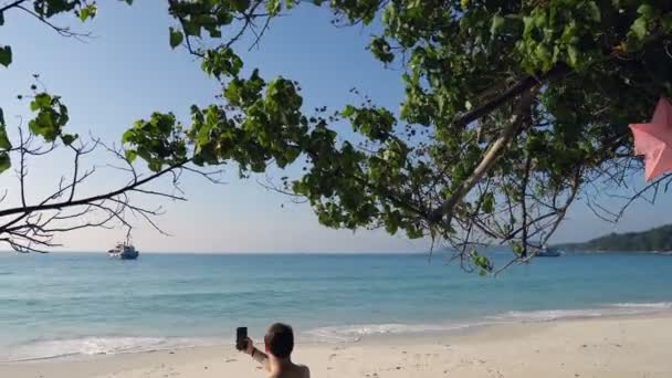 Viaggiatore Seduto Sulla Spiaggia Tropicale Utilizzando Telefono — Video Stock