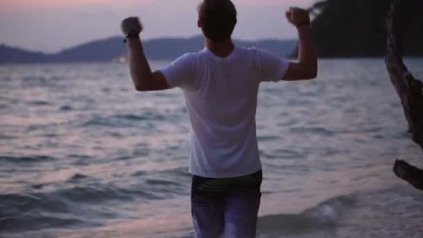 Úspěšný Vzrušený Mladý Muž Tropické Pláži Během Západu Slunce — Stock video