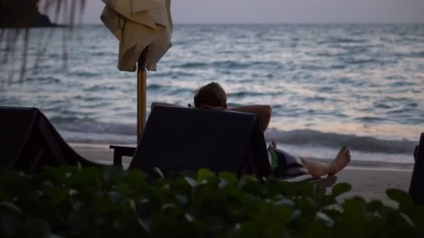 Man Semester Som Ligger Lounger Tropical Resort Beach Tidig Morgon — Stockvideo