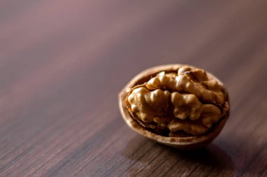 Ahşap masadaki ceviz çekirdekleri, renkli arka plan, ahşap kasede ceviz..