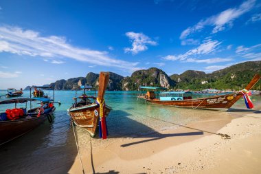 Phi Phi Adası, Tayland - 26 Kasım 2019: Phi Phi Adası 'nda bir plaja park edilmiş geleneksel tahta kuyruklu tekneler. Temiz su ve temiz sahil.