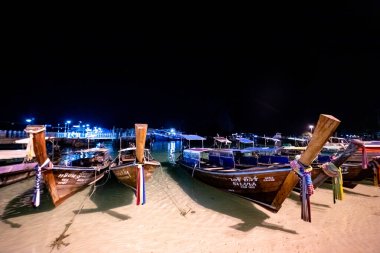 Phi Phi Adası, Tayland - 24 Kasım 2019: Phi Phi Adası 'ndaki Loh Dalum Sahili' ne gece park etmiş geleneksel uzun kuyruklu tekneler.