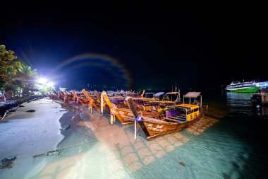 Phi Phi Adası, Tayland - 24 Kasım 2019: Phi Phi Adası 'ndaki Loh Dalum Sahili' ne gece park etmiş geleneksel uzun kuyruklu tekneler.