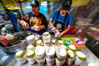 Krabi Town, Thailand - November 23 2019: Locals selling coconut icecream at Krabi Weekend Night Market in Krabi Town, Thailand. clipart