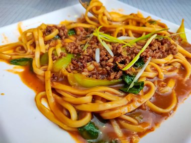 Lo Mein Eriştesi. Düz erişteler beyaz tabakta servis edilir..