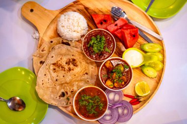 Hint pilavı ve ekmek, tavada körili tavuk ve paneer köri ile meyve ve salata sosu ile servis edilir..