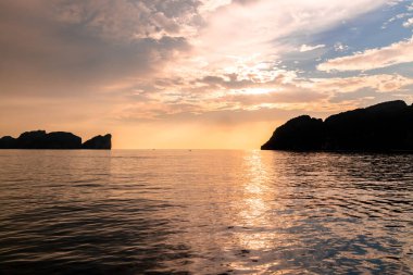 Gün batımında Phi Phi Adaları yakınlarındaki Andrea Denizi 'nin ortasındaki dramatik dağların silueti.