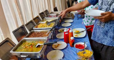 Bir restoranda açık büfe kahvaltısı. Kahvaltıda nefis şeyler servis eden insanlar..