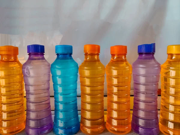 Colorful platic water bottles filled with water.