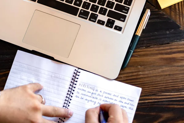 Hand of a young businessman taking notes with a fountain pen on a notecopy.  Student learning online. Blogger. selective focus