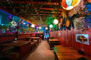 Geceleri bitki ve Çin fenerleriyle süslenmiş bir kafe restoranının içinde.