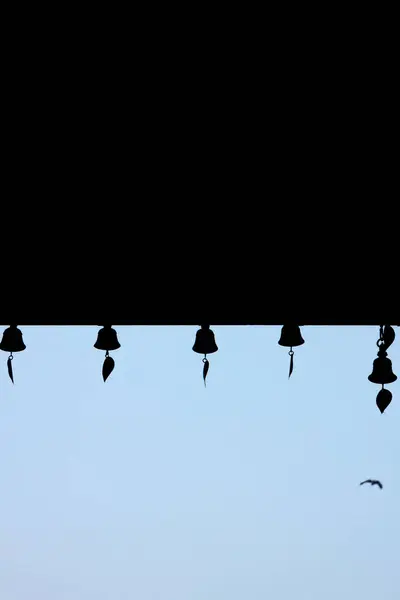Silhouetted Παραδοσιακές Καμπάνες Κρέμονται Από Την Οροφή Ενός Ναού — Φωτογραφία Αρχείου