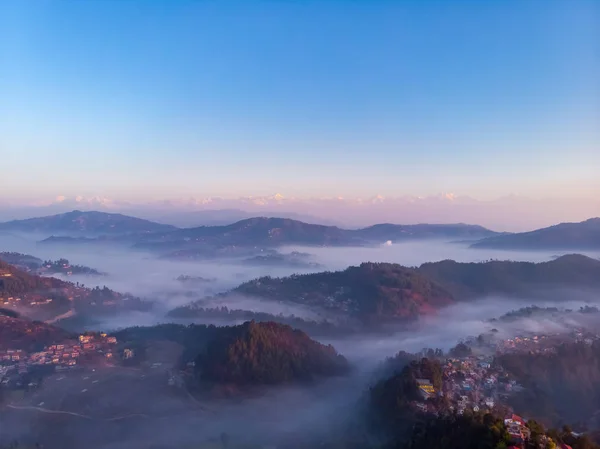 背景にはヒマラヤ山脈と日の出の間に霧に覆われた山々のムーディー劇的な景色 — ストック写真