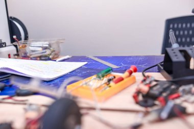 Donanım mühendisi masası. Elektronik parçalar masanın üzerine saçılmış. Tutkulu bir programcının çalışma masası