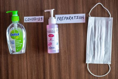 Katmandu, Nepal - 8 Mart 2020: Bir şişe Dettol El Dezenfektanı, Alkol Fırçası ve ahşap bir masaya yerleştirilmiş tek kullanımlık kağıt maske