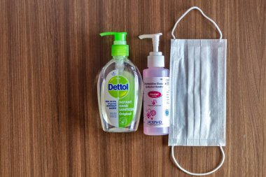 Katmandu, Nepal - 8 Mart 2020: Bir şişe Dettol El Dezenfektanı, Alkol Fırçası ve ahşap bir masaya yerleştirilmiş tek kullanımlık kağıt maske