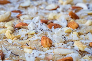 Ev yapımı Semolona tatlıları badem, kaju fıstığı ve hindistan cevizi ovalama malzemeleriyle iyice temizlenmiş. Hindistan 'da Suji ka halwa olarak da bilinir.