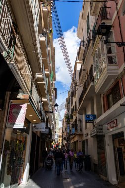 Palma, Mallorca - April 10, 2019: many tourists walking in a old thin street in town of Palma de Malorca, Spain