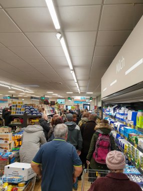Munich, Germany, 14 of april 2020: huge queue in front of the checkout after Pandemic, panic buying, specifically for toilet paper and pasta, has shelves empty, in all major shops in Munich due to the clipart