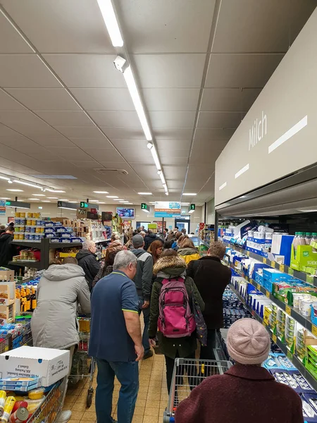 München, Duitsland, 14 april 2020: grote rij voor de kassa na de pandemie, paniek kopen, speciaal voor wc-papier en pasta, heeft planken leeg, in alle grote winkels in München als gevolg van de — Stockfoto