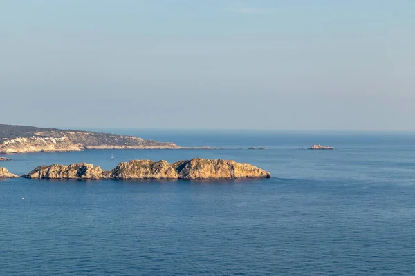 Letecký výhled na skály, útesy, ostrovní a mořskou vodu při západu slunce z vyhlídkového bodu čepice andritxol v Camp de Mar, ostrov Mallorca, Španělsko — Stock fotografie
