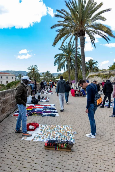 Palma, Mallorca - April 10, 2019: african street vendors try to stell piracy stuff on tourist near the Cathedrale de Palama — Stok fotoğraf