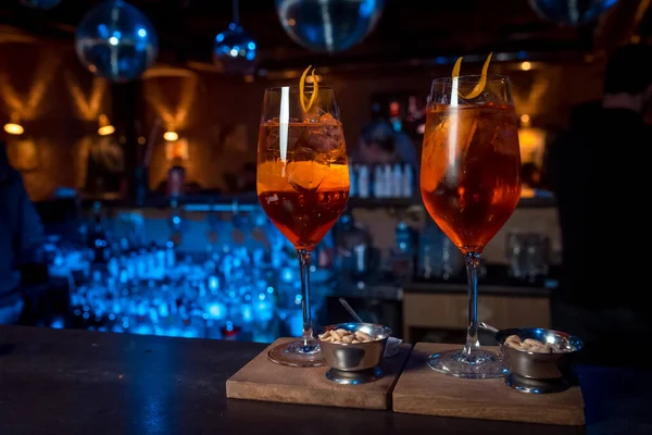 Dois coquetéis alcoólicos laranja com gelo em um suporte de madeira — Fotografia de Stock